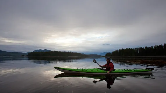 sea kayaker at sunsrise in calm bay at Spring Island